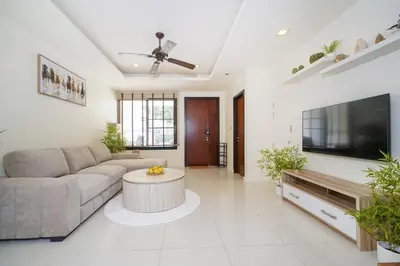 a living room with a couch and a tv at Laguna pool house in Phuket Town
