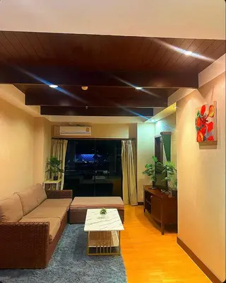 a living room with a couch and a table at Patong Tower Mountain View in Patong Beach