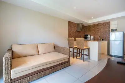 a living room with a couch and a kitchen at Mountain View Apt, High Speed Internet - 1BR-Karon in Kata Beach