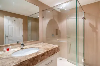 a bathroom with a sink and a glass shower at Mountain View Apt, High Speed Internet - 1BR-Karon in Kata Beach
