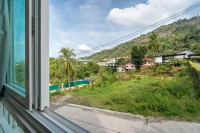 a window with a view of a mountain at Mountain View Apt, High Speed Internet - 1BR-Karon in Kata Beach