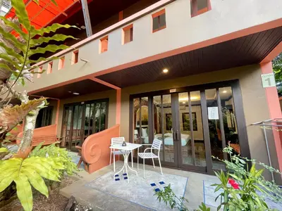 a patio with a table and chairs in front of a building at Fullmoon Beachresort Krabi in Ao Nang Beach