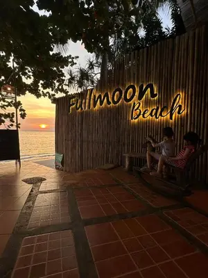 two children sitting on a bench in front of a sign at Fullmoon Beachresort Krabi in Ao Nang Beach
