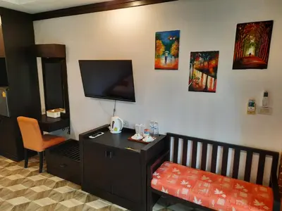 a room with a bed and a desk and a tv at Fullmoon Beachresort Krabi in Ao Nang Beach
