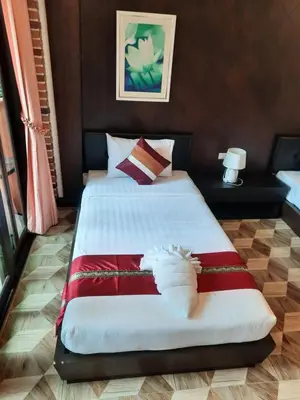 a bedroom with a large bed with red and white sheets at Fullmoon Beachresort Krabi in Ao Nang Beach