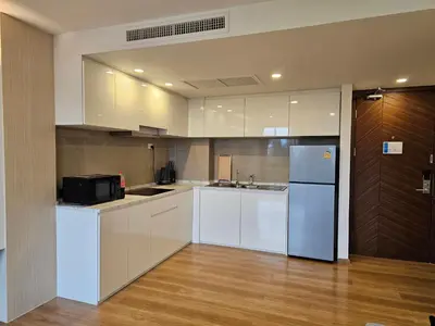 a kitchen with white cabinets and a refrigerator at Duplex Luxury Apartments in 5 Star Hotel in Rawai Beach