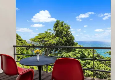a balcony with a table and chairs and the ocean at Villa Yin, Private Oceanfront Villa, Kamala Beach in Kamala Beach