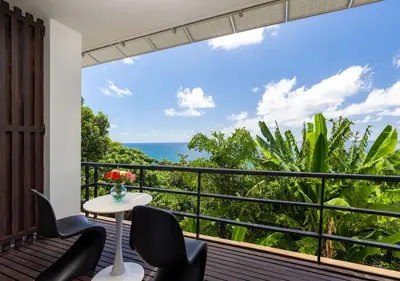 a balcony with a table and chairs and the ocean at Villa Yin, Private Oceanfront Villa, Kamala Beach in Kamala Beach