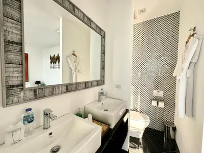a white bathroom with a sink and a mirror at Villa Yin, Private Oceanfront Villa, Kamala Beach in Kamala Beach