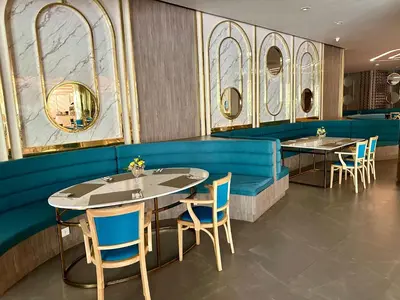 a dining room with tables and chairs and mirrors at La Vita Luxury Apartment in Rawai Beach