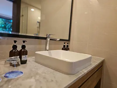 a white sink in a bathroom with a mirror at La Vita Luxury Apartment in Rawai Beach