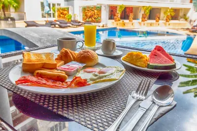 a plate of breakfast food on a table next to a pool at Ocean View Treasure Residence in Patong Beach