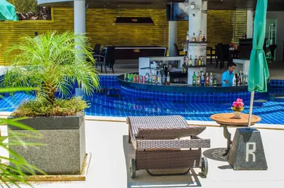 a restaurant with a bar with a table and a palm tree at Ocean View Treasure Residence in Patong Beach