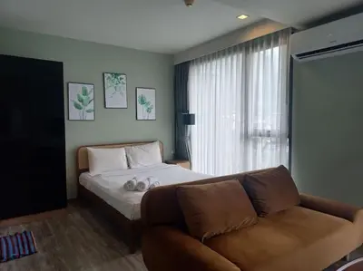 a bedroom with a bed and a couch and a window at The Deck Patong 7Fl Mountain View2 in Patong Beach
