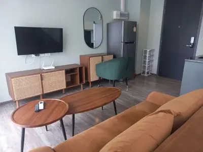 a living room with a couch and tables and a tv at The Deck Patong 7Fl Mountain View2 in Patong Beach