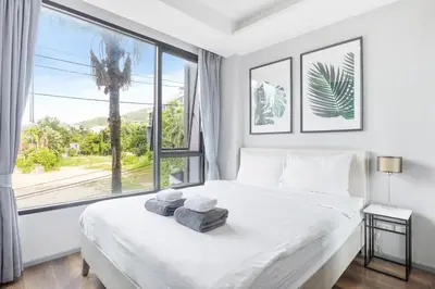 a bedroom with a large bed with towels on it at 6th Avenue Surin Condomium in Surin Beach