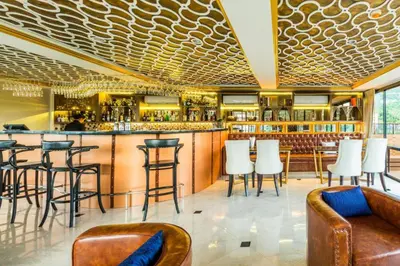 a bar in a restaurant with chairs and a counter at 6th Avenue Surin Condomium in Surin Beach