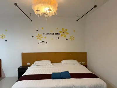 a bedroom with a bed with flowers on the wall at \u592a\u9633\u82b1\u9152\u5e97\u4eb2\u5b50\u5957\u623f in Patong Beach