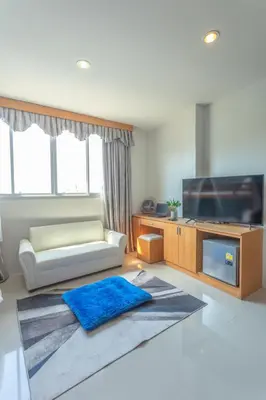 a living room with a couch and a flat screen tv at \u592a\u9633\u82b1\u9152\u5e97\u4eb2\u5b50\u5957\u623f in Patong Beach