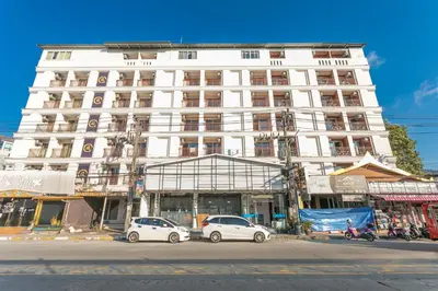 a white building with cars parked in front of it at \u592a\u9633\u82b1\u9152\u5e97\u4eb2\u5b50\u5957\u623f in Patong Beach
