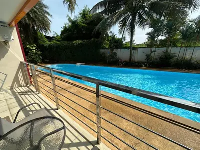 a swimming pool with a metal railing next to a house at 1 - Bedroom Apartment Pool Access, 750m to the Beach in Mai Khao Beach