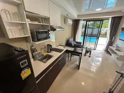 a kitchen and living room with a sink and a refrigerator at 1 - Bedroom Apartment Pool Access, 750m to the Beach in Mai Khao Beach