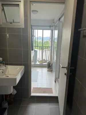 a bathroom with a sink and a door to a balcony at D-Condo Mine Kathu in Ban Ket Ho