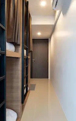 a room with a corridor with bunk beds and a door at Kata Beach Poshtel Phuket in Kata Beach