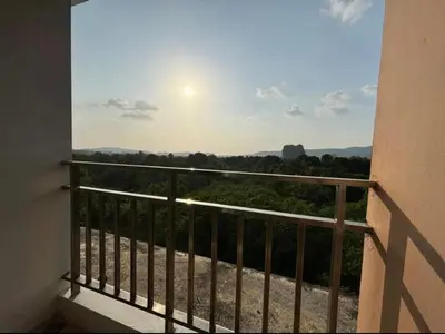 a balcony with a view of trees and the sun at มัณดาวีต์ คอนโดa in Ban Khlong Son