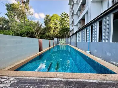 a swimming pool on the side of a building at มัณดาวีต์ คอนโดa in Ban Khlong Son