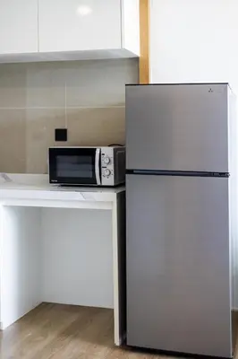 a stainless steel refrigerator in a kitchen with a microwave at Suite Marella 1BR Pools Shuttle to Nai Harn in Rawai Beach