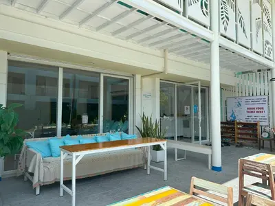 a patio with a couch and a table with blue pillows at Blue Horizon Hostel By Blue Flow in Phi Phi Don