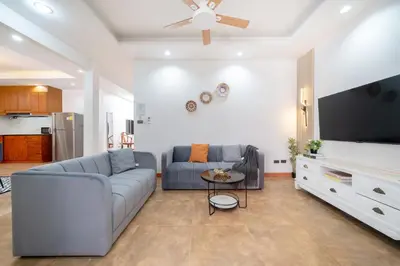 a living room with a couch and a flat screen tv at Patong private home 4BR Jazzuci sleep 10 in Patong Beach