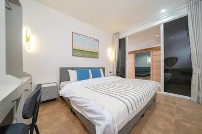 a bedroom with a large bed with blue pillows at Patong private home 4BR Jazzuci sleep 10 in Patong Beach
