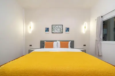a bedroom with a large yellow bed with orange pillows at Patong private home 4BR Jazzuci sleep 10 in Patong Beach