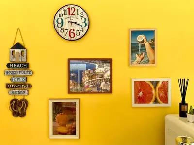 a wall with pictures and a clock on it at Sweett Lemon Hostel in Patong Beach