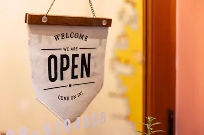 a sign that says welcome we are open at Sweett Lemon Hostel in Patong Beach