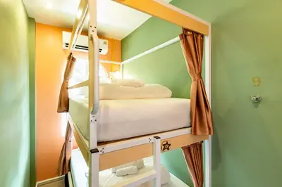a bunk bed in a room with green walls at Sweett Lemon Hostel in Patong Beach