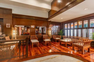 a lobby with chairs and tables and a bar at Rattana Karon Beach Hotel in Karon Beach