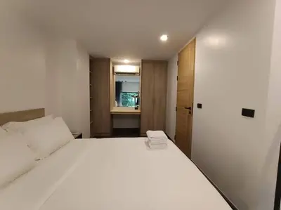 a bedroom with a large white bed and an open door at Utopia Naiharn - Room3 - B124 in Rawai Beach