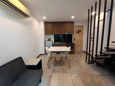 a living room with a table and a kitchen at Utopia Naiharn - Room3 - B124 in Rawai Beach