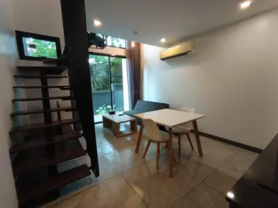 a dining room with a table and chairs and a staircase at Utopia Naiharn - Room3 - B124 in Rawai Beach