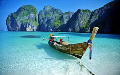 a boat sitting in the water on a beach at XX Bao Patong Beach PHUKET เบา หาดป่าตอง ภูเก็ต in Patong Beach
