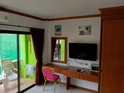 a room with a desk with a television and a window at Kata Goran in Kata Beach