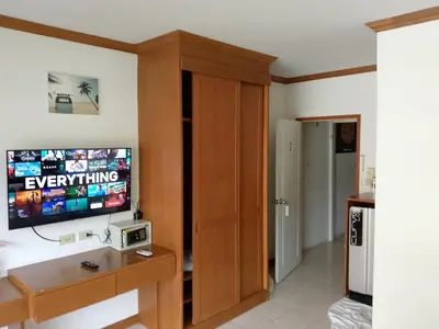 a living room with a flat screen tv on a wall at Kata Goran in Kata Beach