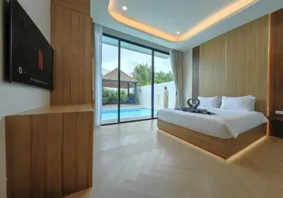 a bedroom with a bed and a television and a pool at Bangtao Luxury Pool Villa - PrymaVerde in Laguna Phuket