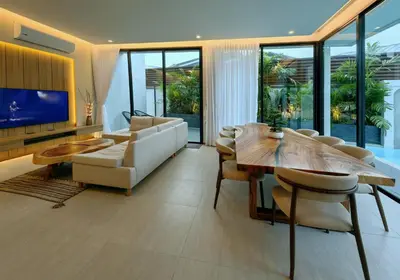 a living room with a wooden table and a couch at Bangtao Luxury Pool Villa - PrymaVerde in Laguna Phuket