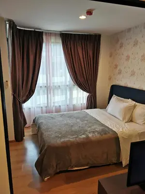 a bedroom with a large bed in front of a window at Centrio Phuket C3 in Ban Rangeng