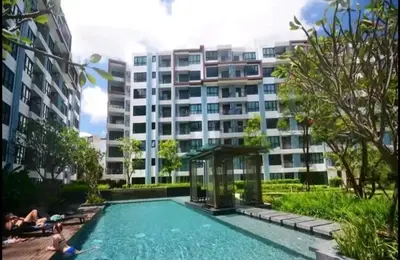 a swimming pool in front of a large building at Centrio Phuket C3 in Ban Rangeng