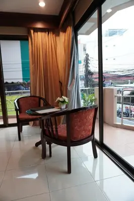 a table and chair in a room with a window at Centre Point Nanai in Patong Beach